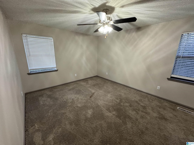 empty room with ceiling fan, carpet floors, and a textured ceiling