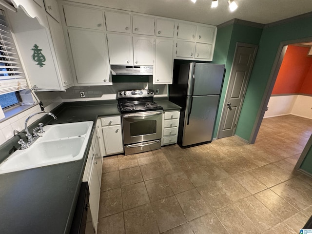 kitchen featuring sink, decorative backsplash, ornamental molding, appliances with stainless steel finishes, and white cabinetry