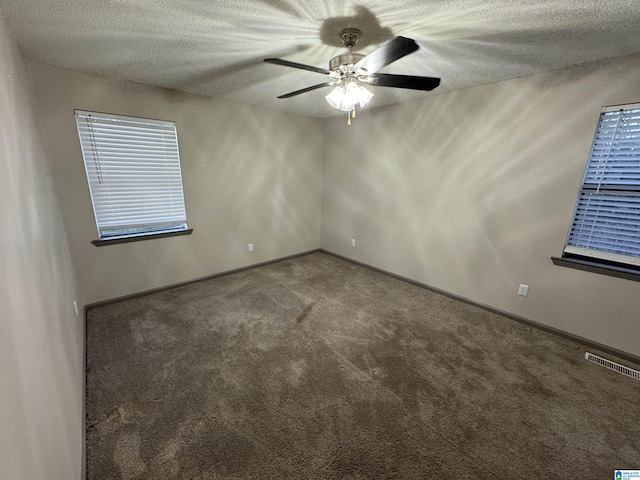 carpeted spare room featuring a textured ceiling and ceiling fan