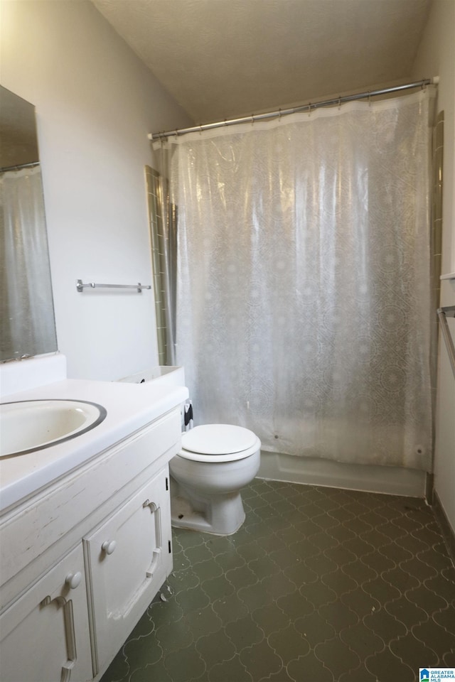 bathroom with tile patterned flooring, vanity, and toilet