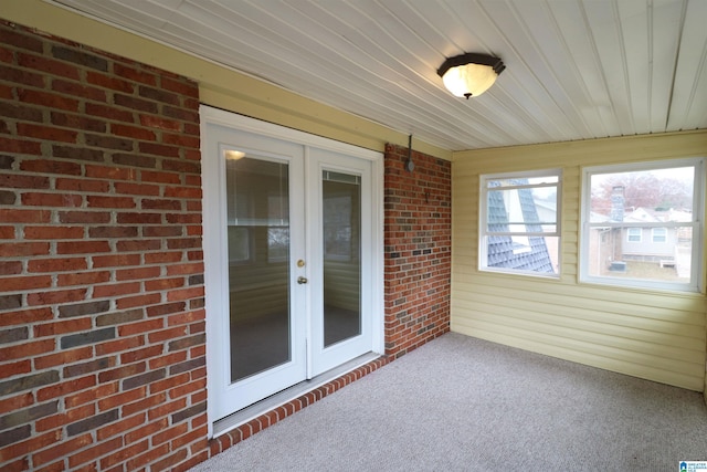 unfurnished sunroom featuring wood ceiling and french doors