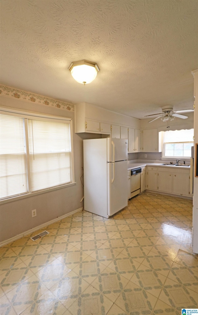 kitchen featuring a textured ceiling, white appliances, ceiling fan, and sink