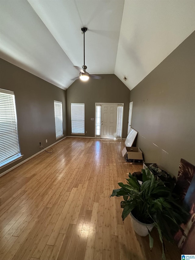 unfurnished living room with ceiling fan, light hardwood / wood-style floors, and lofted ceiling