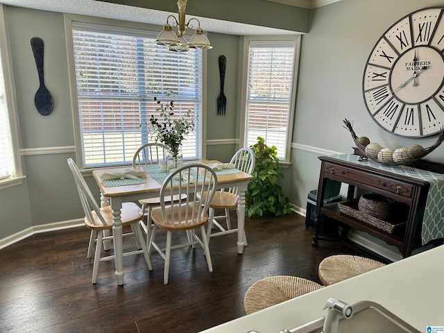 dining room with a wealth of natural light, dark hardwood / wood-style floors, and an inviting chandelier