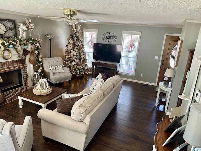 living room with ceiling fan, ornamental molding, a textured ceiling, a fireplace, and dark hardwood / wood-style flooring