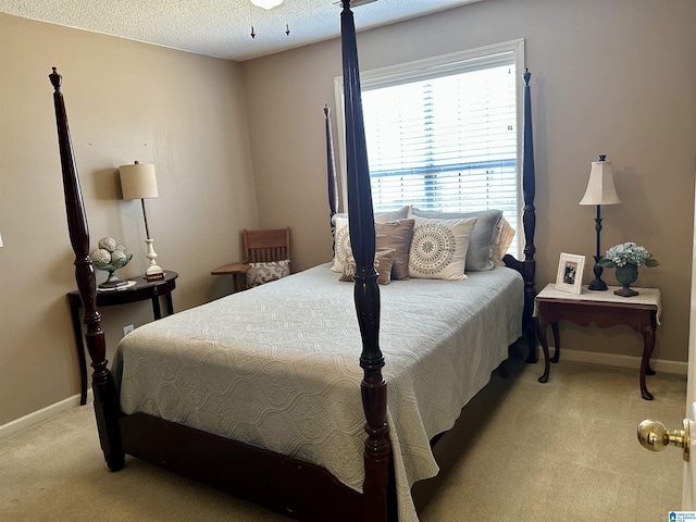 carpeted bedroom featuring ceiling fan and a textured ceiling