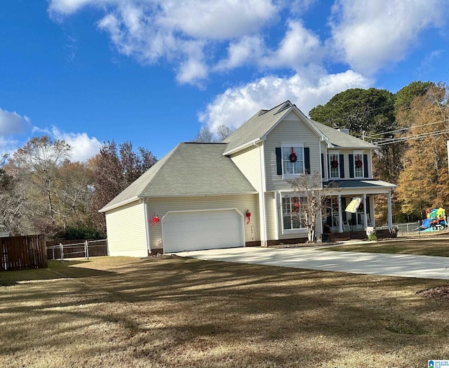 view of front of home with covered porch, a garage, and a front yard