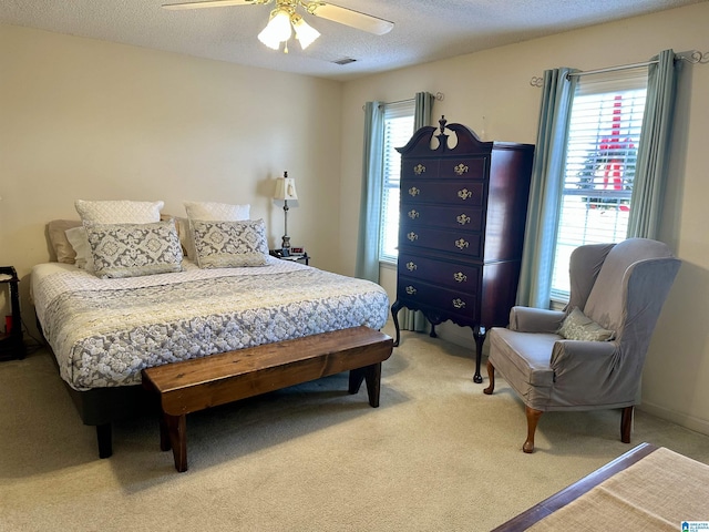 bedroom with carpet, a textured ceiling, and ceiling fan