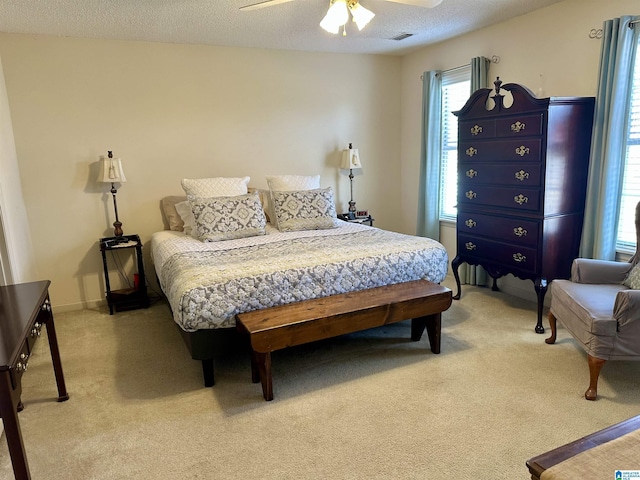 bedroom featuring a textured ceiling, carpet floors, and ceiling fan