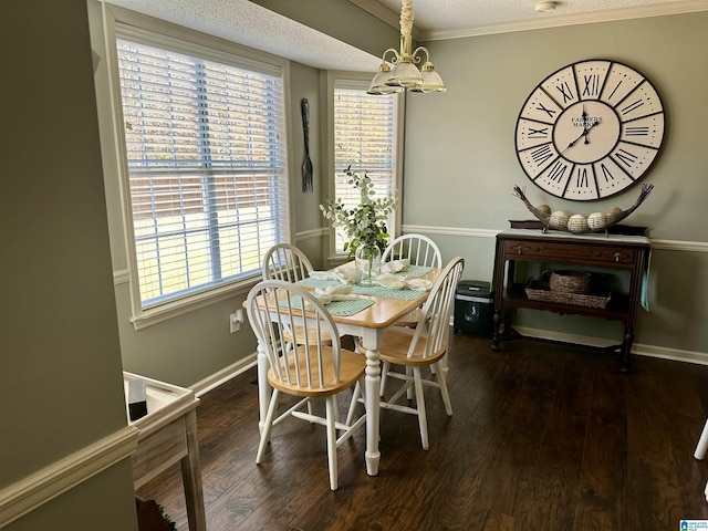 dining area featuring dark hardwood / wood-style flooring, a chandelier, a textured ceiling, and ornamental molding