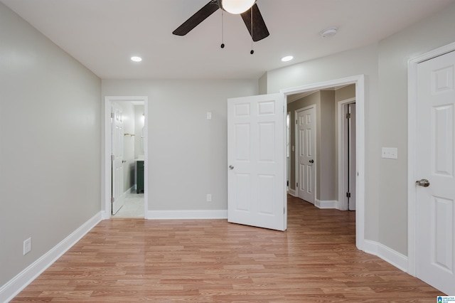 unfurnished bedroom with ensuite bath, ceiling fan, and light wood-type flooring