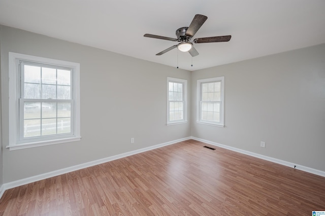 spare room featuring hardwood / wood-style flooring, plenty of natural light, and ceiling fan