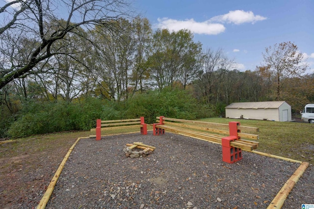 view of play area featuring an outbuilding, a yard, and a fire pit