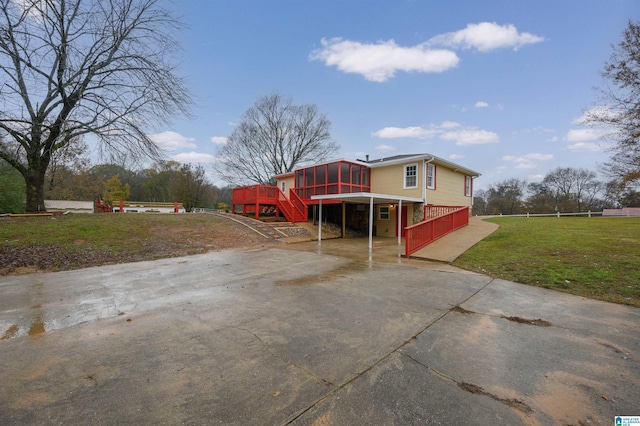 view of front of house featuring a sunroom, a deck, and a front lawn