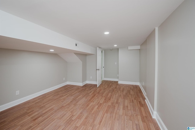 basement with light hardwood / wood-style flooring