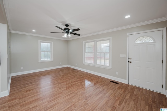 foyer entrance featuring plenty of natural light, light hardwood / wood-style flooring, ceiling fan, and crown molding