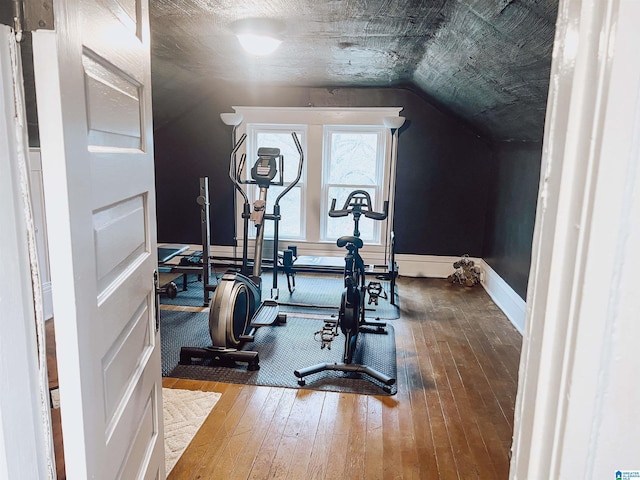 workout room with wood-type flooring and vaulted ceiling