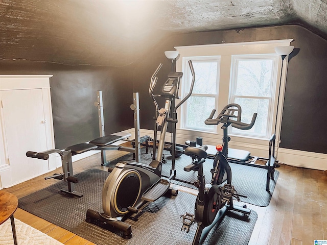 workout room featuring hardwood / wood-style floors and lofted ceiling