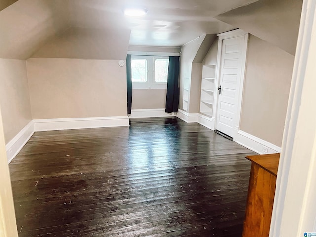 additional living space with dark hardwood / wood-style floors and lofted ceiling