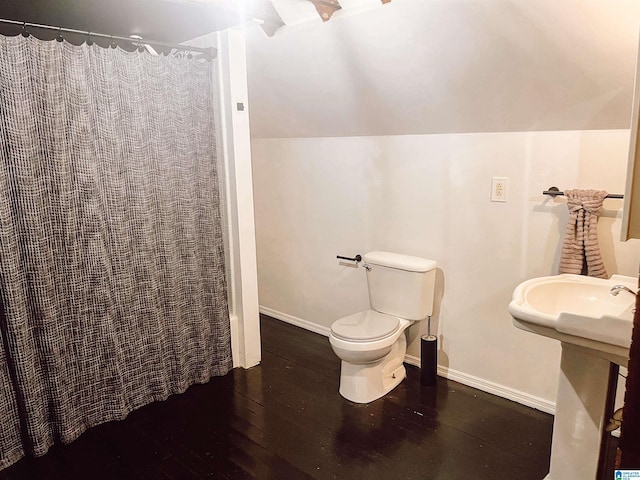 bathroom featuring sink, toilet, lofted ceiling, and hardwood / wood-style flooring