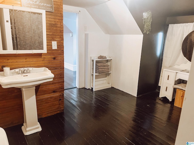 bathroom with wood-type flooring, lofted ceiling, and wood walls