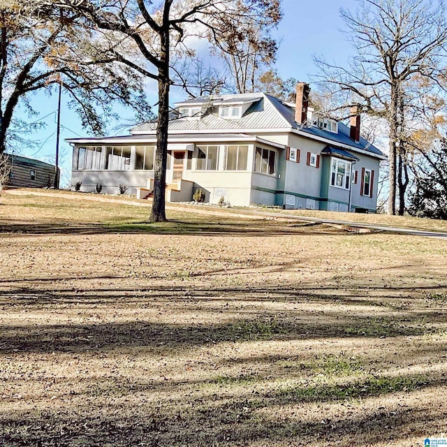 view of front facade with a sunroom and a front lawn