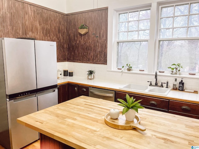 kitchen featuring dark brown cabinetry, decorative backsplash, sink, and stainless steel appliances