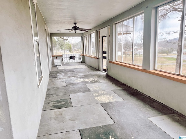 unfurnished sunroom featuring ceiling fan