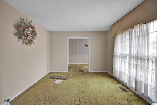 carpeted empty room featuring a textured ceiling