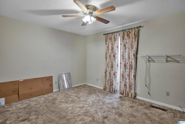 unfurnished room featuring a textured ceiling, ceiling fan, and light carpet