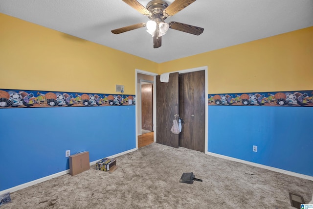 unfurnished bedroom with carpet flooring, ceiling fan, a closet, and a textured ceiling