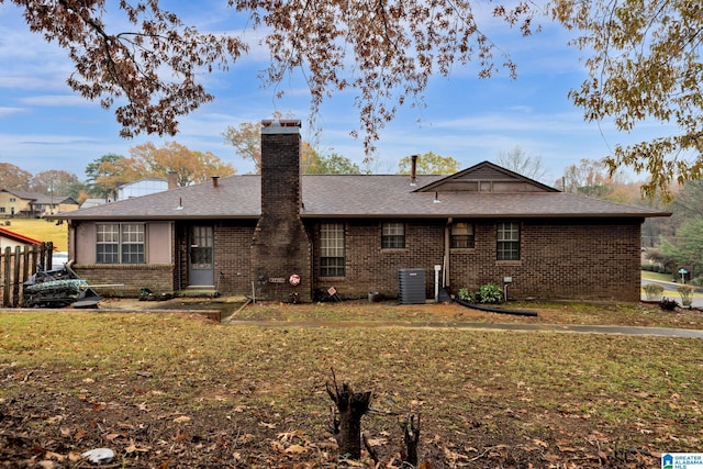 rear view of property featuring a lawn and central AC