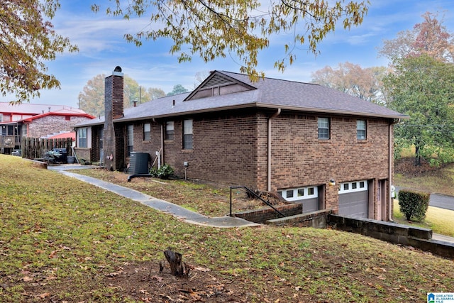 view of side of home with a garage, cooling unit, and a lawn