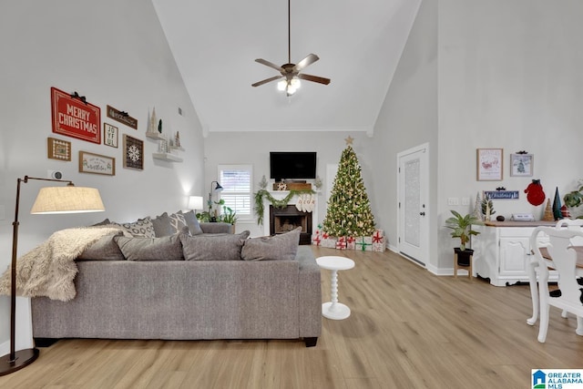 living room with light hardwood / wood-style floors, high vaulted ceiling, and ceiling fan