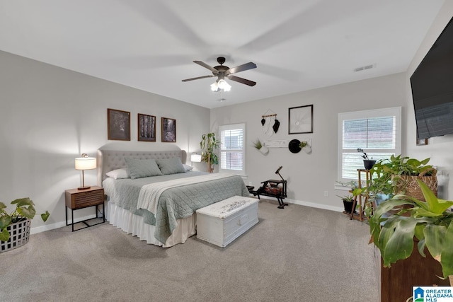 carpeted bedroom with multiple windows and ceiling fan