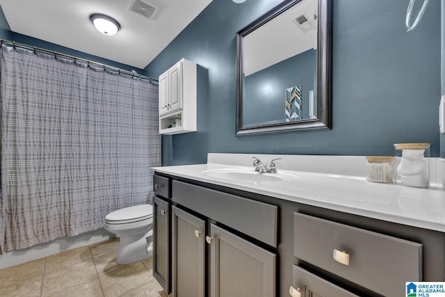 bathroom with toilet, vanity, and tile patterned floors