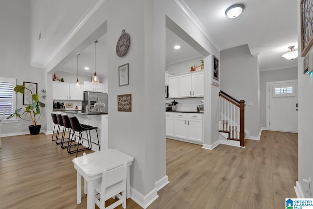 interior space with light wood-type flooring and ornamental molding