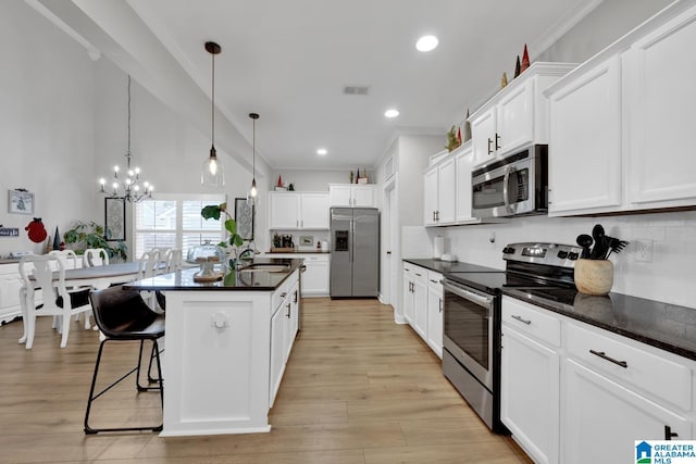 kitchen featuring pendant lighting, a center island with sink, light hardwood / wood-style floors, white cabinetry, and stainless steel appliances