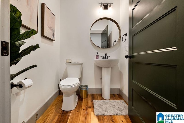 bathroom with hardwood / wood-style floors and toilet