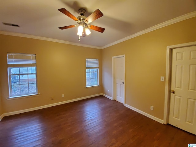 empty room with dark hardwood / wood-style floors, crown molding, ceiling fan, and a healthy amount of sunlight