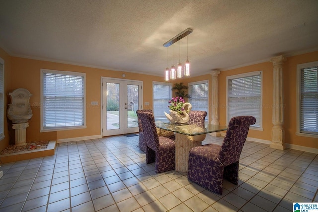 dining room featuring french doors, decorative columns, a textured ceiling, light tile patterned flooring, and ornamental molding