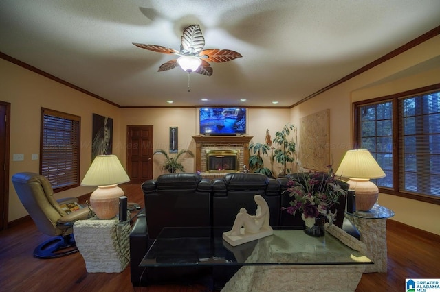 living room with hardwood / wood-style floors, ceiling fan, ornamental molding, and a brick fireplace