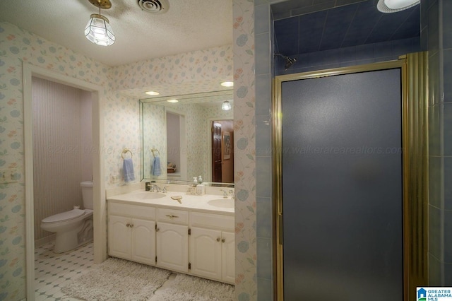 bathroom featuring vanity, tile patterned flooring, toilet, a textured ceiling, and a shower with shower door