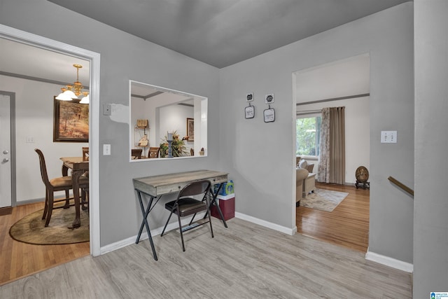 interior space featuring a chandelier, light hardwood / wood-style flooring, and ornamental molding