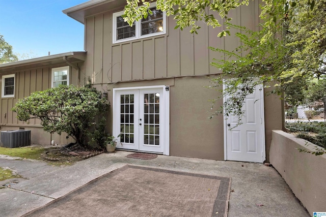 view of exterior entry with french doors, a patio area, and central air condition unit