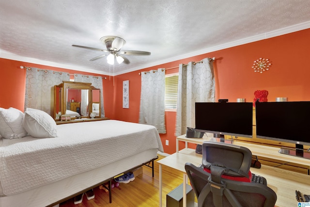 bedroom with a textured ceiling, ceiling fan, wood-type flooring, and crown molding