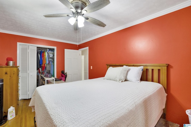 bedroom with ceiling fan, light hardwood / wood-style floors, ornamental molding, and a closet