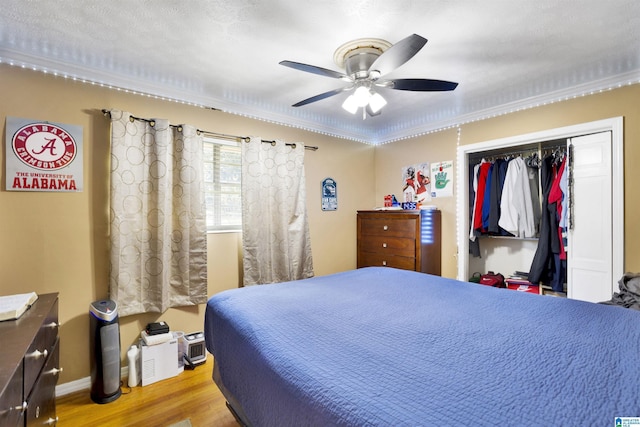 bedroom with hardwood / wood-style floors, ceiling fan, and a closet