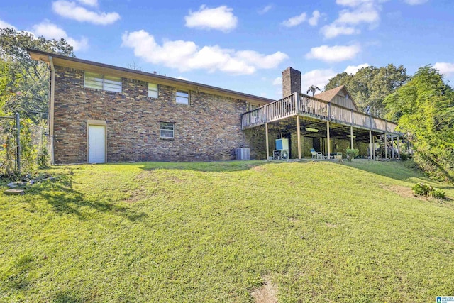 rear view of house with a lawn, a wooden deck, and central air condition unit