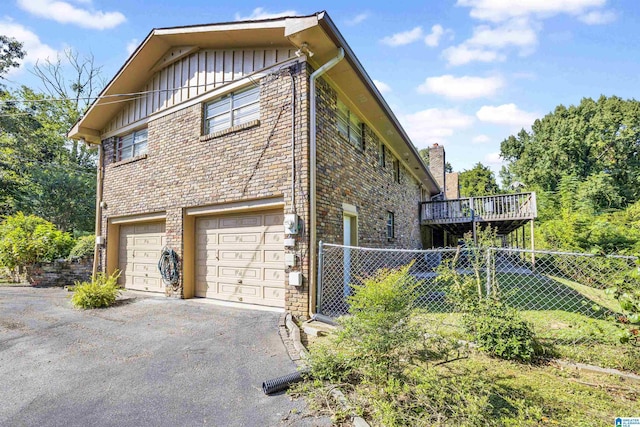 view of side of home featuring a deck and a garage